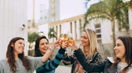  Ein Foto von vier schönen ausländischen Frauen, die ihre Gläser Champagner anstoßen